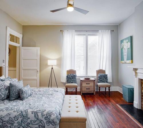 - une chambre avec un lit, deux chaises et une fenêtre dans l'établissement 414B Waldburg st · 2 Bedroom Oasis near Forsyth Park, à Savannah