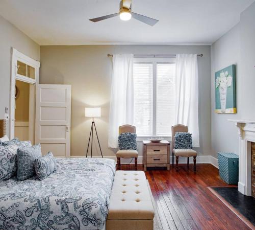 a bedroom with a bed and two chairs and a window at 414B Waldburg st · 2 Bedroom Oasis near Forsyth Park in Savannah