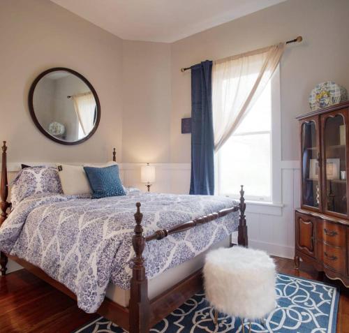 una camera da letto con un letto con specchio e una finestra di 416A Waldburg st · Newly Renovated 1920's Historic District Apt a Savannah