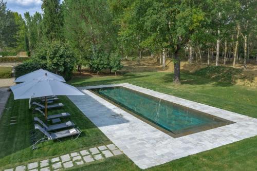 an overhead view of a swimming pool with an umbrella and chairs at Viesca Toscana Suites & Villas in Reggello