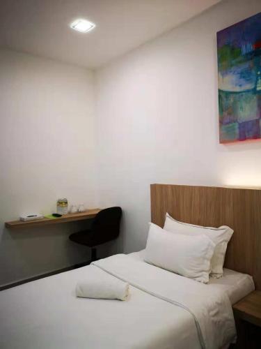 a bedroom with a bed and a desk with a chair at i-homey guesthouse in Alor Setar