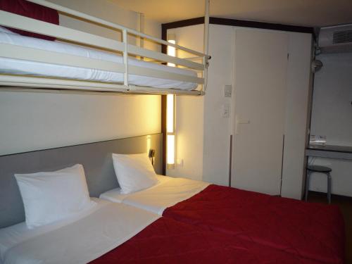 a bedroom with a bed and a bunk bed at Première Classe Valence Sud in Valence