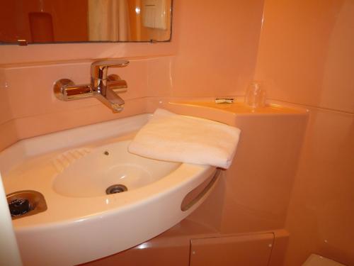 a small bathroom with a sink and a mirror at Première Classe Valence Sud in Valence