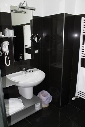 a bathroom with a sink and a glass shower at Halanus Hotel And Resort in Alanno