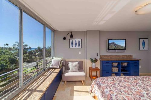 a bedroom with a bed and a balcony at @ Marbella Lane Studio, 15 steps from the Beach, 11 mins from the Airport in Honolulu