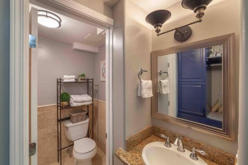 a bathroom with a toilet and a sink and a mirror at @ Marbella Lane Studio, 15 steps from the Beach, 11 mins from the Airport in Honolulu
