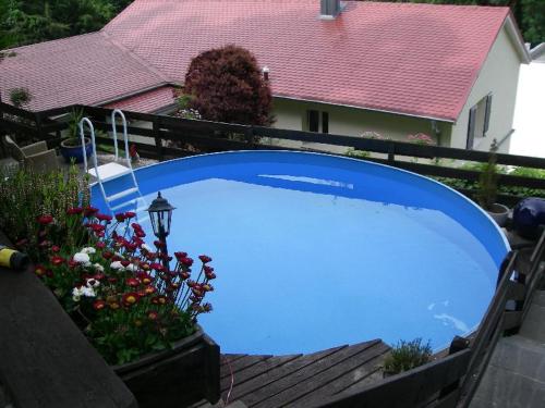 a large blue swimming pool in front of a house at Haus Seeromantik in Uhldingen-Mühlhofen