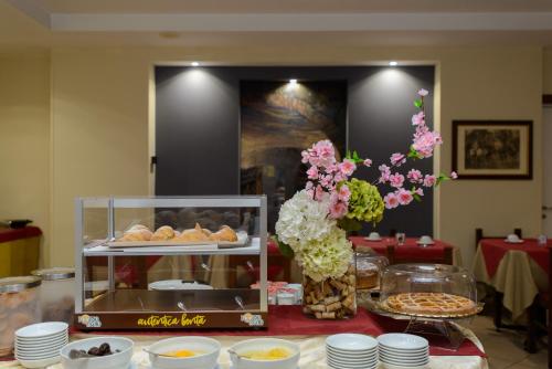 a table with a display of pastries and flowers at Bes Hotel Papa San Pellegrino Terme in San Pellegrino Terme