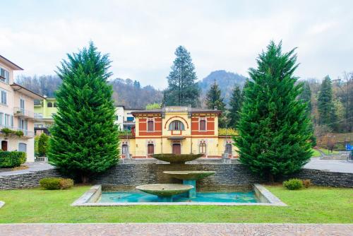 un parque con una fuente frente a un edificio en Bes Hotel Papa San Pellegrino Terme en San Pellegrino Terme