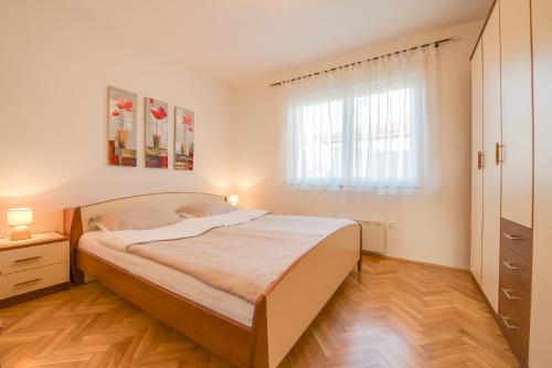 a bedroom with a large bed and a window at Villa Cera Vodnjan in Vodnjan