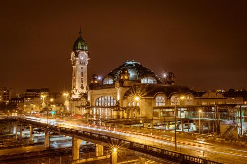 un grand bâtiment avec une tour d'horloge la nuit dans l'établissement Kyriad Limoges Centre Gare - Atrium, à Limoges