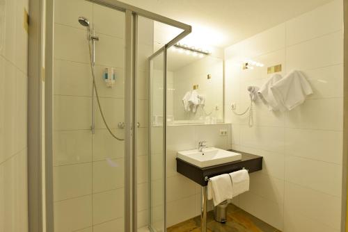 a bathroom with a sink and a shower at INVITE Hotel Nürnberg City in Nürnberg