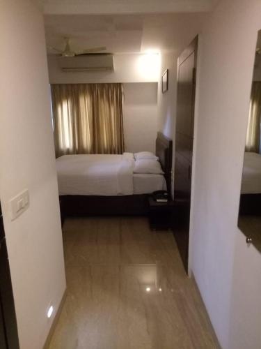 a hotel room with two beds and a hallway at Calangute Grande in Calangute