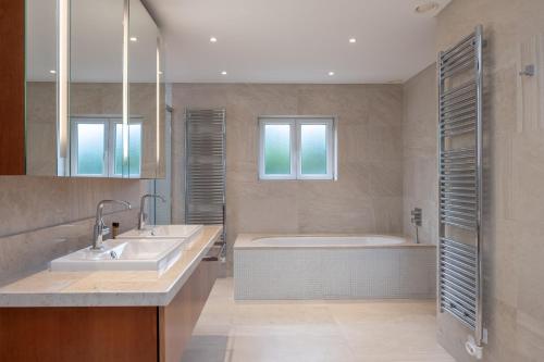 uma casa de banho com uma banheira e um lavatório em Deslumbrante V6 em Praia del Rei
