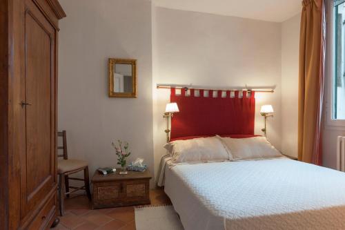 Schlafzimmer mit einem großen Bett mit einem roten Kopfteil in der Unterkunft Grand Piano Apartment in Florenz