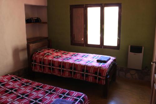 a room with two beds and a window at Cabañas Maimará in Maimará