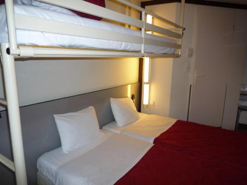 a bedroom with a bunk bed with two pillows at Première Classe Valence Sud in Valence