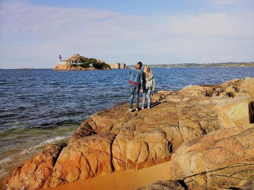 two people standing on rocks by the water at L'écurie Kerdoel in Cléder