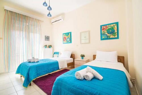 two beds in a room with blue and white at Sissy’s House in Preveza