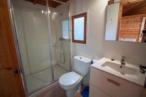 a bathroom with a toilet and a shower and a sink at Camping Joan Bungalow Park in Cambrils