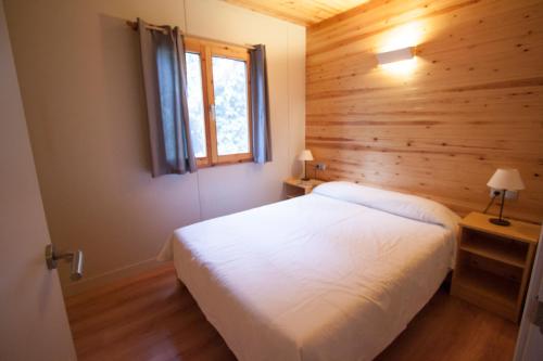 a bedroom with a white bed and a window at Camping Joan Bungalow Park in Cambrils