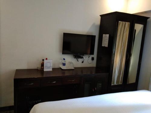 a hotel room with a bed and a television at Calangute Grande in Calangute