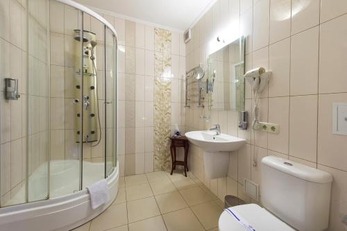 a bathroom with a shower toilet and a sink at Villa Oselya in Kyiv