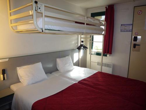 een bed in een kamer met 2 stapelbedden bij Première Classe Valence Sud in Valence