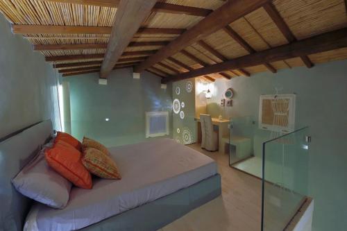 um quarto com uma cama com almofadas em Corte Dei Granai em Maglie