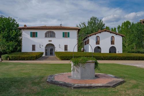 a large white house with green shutters at Viesca Toscana Suites & Villas in Reggello