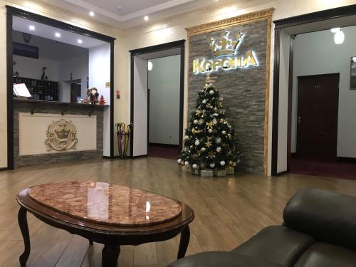 a christmas tree in a lobby with a coffee table at Korona in Nalchik