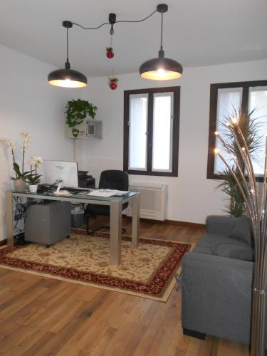 an office with a desk with a computer and a couch at LOCANDA RIGHETTO in Quinto di Treviso