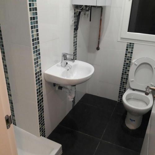 a bathroom with a sink and a toilet at Habitaciones en Ronda in Castro-Urdiales