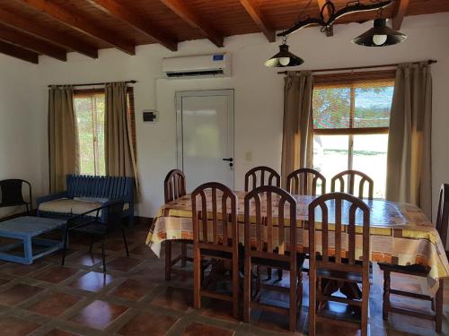 uma sala de jantar com uma mesa de madeira e cadeiras em Rancho Aparte em Ituzaingó