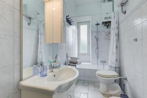 bagno bianco con lavandino e servizi igienici di Cheap&Chic a Roma