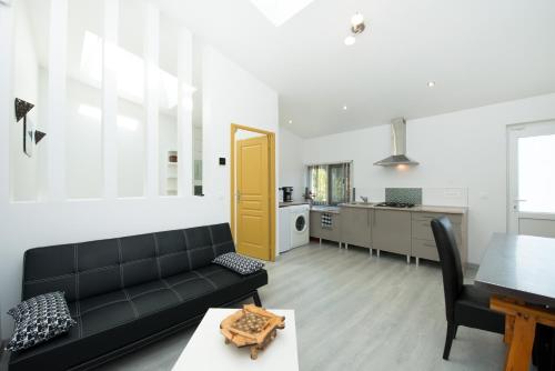 a living room with a black couch and a table at Gîte de vac's et d'affaires à Deville Secteur Monthermé - Ardennes in Deville