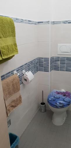 a bathroom with a blue and white toilet and towels at intero appartamento con giardino e colazione Dario in Parma