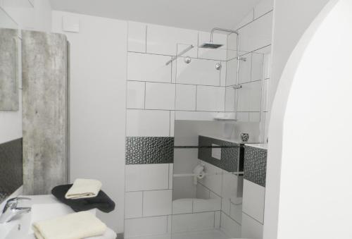 a white bathroom with a sink and a shower at Gîte de vac's et d'affaires à Deville Secteur Monthermé - Ardennes in Deville