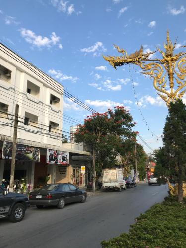 a street with cars parked on the side of the road at Hug House in Chiang Rai