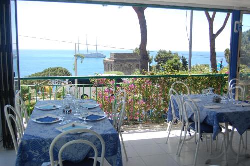 a table and chairs with a view of the ocean at Villaggio Residence Nettuno in Massa Lubrense
