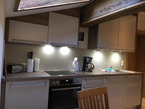 a kitchen with white cabinets and a stove top oven at Ramseiderhof in Saalfelden am Steinernen Meer