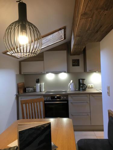 a kitchen with a table and aendant light at Ramseiderhof in Saalfelden am Steinernen Meer
