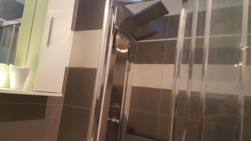 a shower in a bathroom with black and white tiles at DAVID-IN in Zagreb