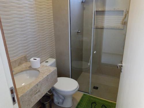 uma casa de banho com um chuveiro, um WC e um lavatório. em Vila Caluca em Olímpia