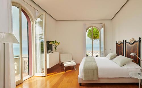 a bedroom with a large bed and large windows at Villa Paola in Tropea