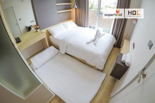 een kleine kamer met 2 bedden en een raam bij HOC4 @Play Condo MAYA Nimmand Road Cozy & Relax in Chiang Mai