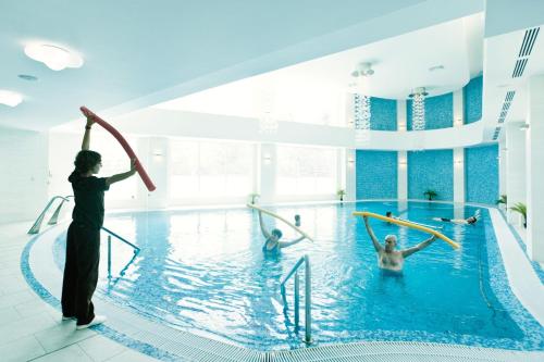 a woman standing in a swimming pool with a gymnastic at Mirage Medspa Hotel in Eforie Nord