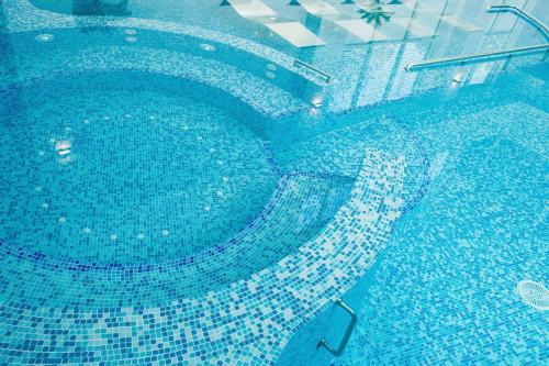 an overhead view of a swimming pool with blue tiles at Mirage Medspa Hotel in Eforie Nord