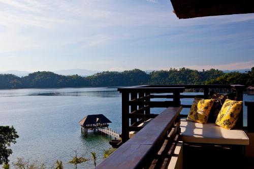 a porch with a view of a lake and a dock at Gaya Island Resort, Kota Kinabalu - a Small Luxury Hotels of the World in Gaya Island