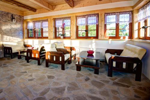 a living room with chairs and tables and windows at Noclegi Styrnol & SPA in Zawoja